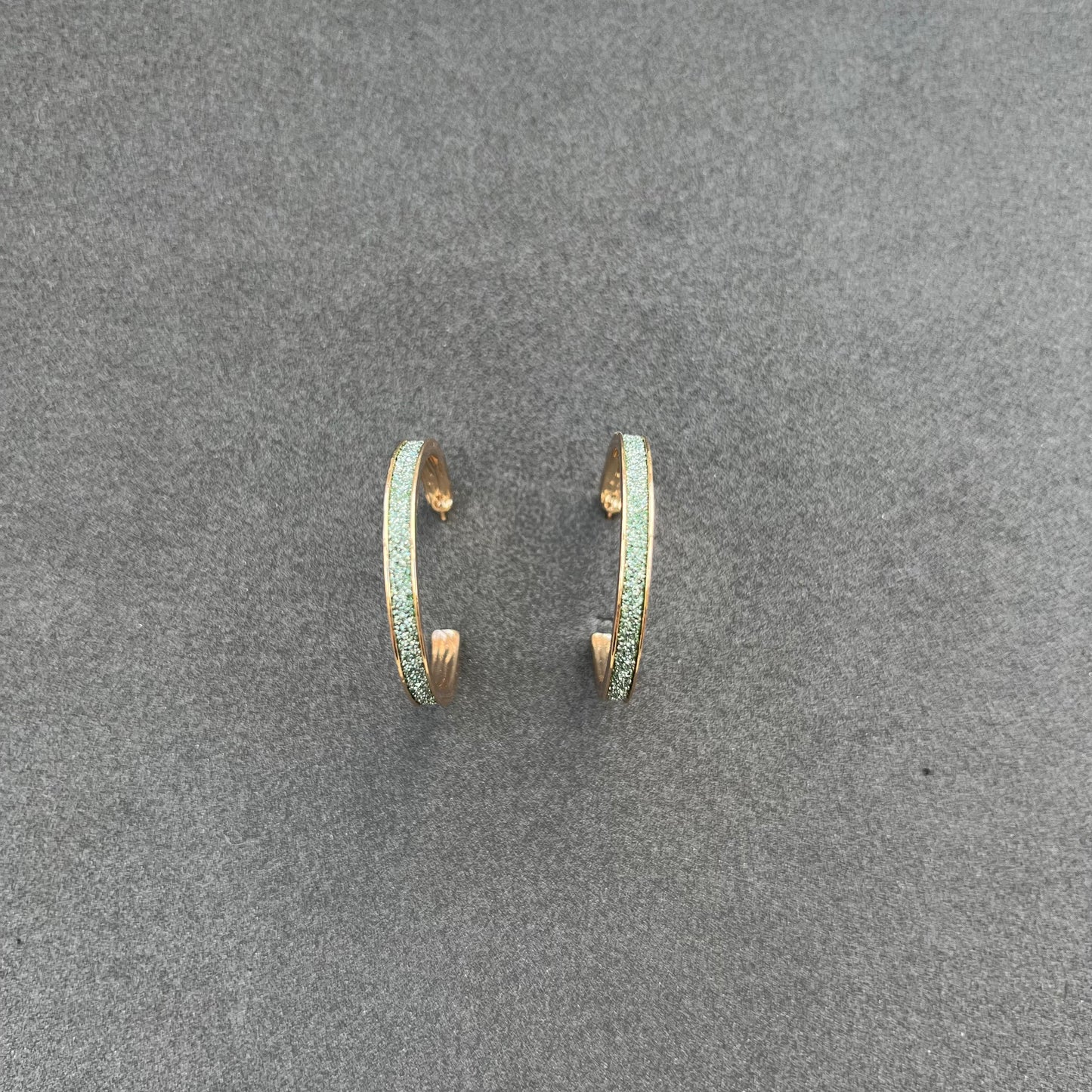 Gold colored earrings with green glitter